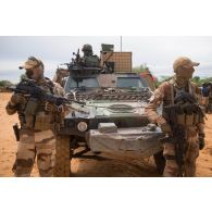 Des soldats du 28e groupe géographique (GG) patrouillent au pied de leur véhicule blindé léger (VBL) dans les rues de Gossi, au Mali.