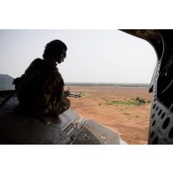 Un membre opérationnel de soute (MOS) britannique sécurise le périmètre en trappe arrière d'un hélicoptère Chinook Ch-47, au Mali.