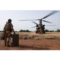 Des soldats du 1er régiment de tirailleurs (RTir) embarquent leur matériel à bord d'un hélicoptère Chinook Ch-47 britannique à Djibo, au Burkina Faso.