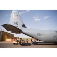Déchargement de matériel par le détachement de transit interarmées (DéTIA) depuis un avion Hercules C-130 de l'armée de l'Air américaine sur l'aérodrome de Gao, au Mali.