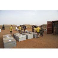 Des marsouins du 2e régiment d'infanterie de marine (2e RIMa) chargent des caisses d'armement à bord d'un container sous le contrôle de prévôts à Gao, au Mali.