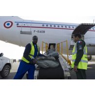 Un personnel de soute de l'escadron de transport 3/60 Esterel supervise le déchargement de matériel depuis la soute d'un avion Airbus A310 sur l'aéroport de Bamako, au Mali.