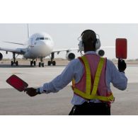 Un employé civil malien guide l'arrivée d'un avion Airbus A310 de l'escadron de transport 3/60 Esterel sur le tarmac de l'aéroport de Bamako, au Mali.