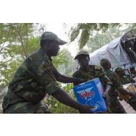 Des soldats togolais déchargent des cartons de bouteilles d'eau à l'arrière d'un camion sur l'aéroport de Bamako, au Mali.