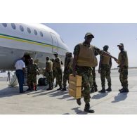 Déchargement de fret depuis un avion Fokker F28 par des soldats togolais sur l'aéroport de Bamako, au Mali.