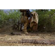 Un sapeur rassemble des muntions pour mitrailleuse lourde découvertes dans une cache d'armes de la région de Teurteli, au Mali.