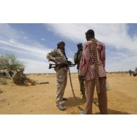 Des soldats maliens font un point de situation avec un milicien pour la sécurisation du périmètre autour de Gao, au Mali.