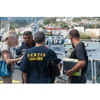 Des officiers de police judiciaire discutent avec l'équipage de la frégate de surveillance Ventôse sur le pont du bâtiment à Fort-de-France, en Martinique.