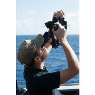 Un second-maître calcule un point de navigation au moyen d'un sextan à bord de la frégate de surveillance Ventôse, en mer des Caraïbes.