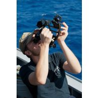 Un second-maître calcule un point de navigation au moyen d'un sextan à bord de la frégate de surveillance Ventôse, en mer des Caraïbes.