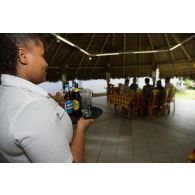 Une volontaire apporte les commandes des clients lors d'un cours pratique sur le service à table au restaurant pédagogique du régiment du service militaire adapté (RSMA) à Saint-Jean-du-Maroni, en Guyane française.