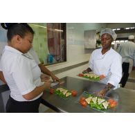 La volontaire Mailysse prépare les commandes des clients lors d'un cours pratique sur le service à table au restaurant pédagogique du régiment du service militaire adapté (RSMA) à Saint-Jean-du-Maroni, en Guyane française.