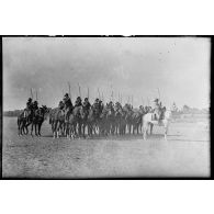 Un peloton à cheval du 7e régiment de chasseurs à cheval (RCC) fait un exercice de présenter de sabres.