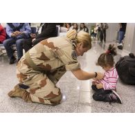 Le lieutenant Maria-Antonia offre un pin's de l'armée de l'air à un enfant de ressortissants irakiens à l'aéroport d'Erbil, dans le Kurdistan irakien.