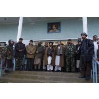 Photographie de groupe lors du rassemblement des factions afghanes à Mazar e Charif : le général Ata (coiffre grise et manteau kaki), le chef de guerre Haji Muhammad Mohaqiq (coiffure traditionnelle grise et manteau marron) et ses partisans sous le portrait du commandant Massoud.