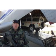 Déchargement d'un véhicule 4x4 ambulance de l'ONG The HALO Trust d'un avion-cargo de transport Iliouchine 76 de la compagnie arménienne Yerevan-Avia, affrété par le Royaume-Uni dans un but humanitaire pour l'acheminement de véhicules, sur l'aéroport de Mazar e Charif, sécurisé par les marsouins du 21e RIMa (régiment d'infanterie de marine). Sentinelle postée en sécurisation.