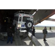 Déchargement d'un véhicule 4x4 ambulance de l'ONG The HALO Trust d'un avion-cargo de transport Iliouchine 76 de la compagnie arménienne Yerevan-Avia, affrété par le Royaume-Uni dans un but humanitaire pour l'acheminement de véhicules, sur l'aéroport de Mazar e Charif, sécurisé par les marsouins du 21e RIMa (régiment d'infanterie de marine). Sentinelle postée en sécurisation.