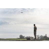 Un instructeur du 1er régiment de chasseurs parachutistes (1er RCP) observe le vol d'un avion Super Hercules sur la zone de saut de Wright à l'école des troupes aéroportées (ETAP) de Pau.