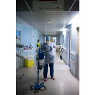Une étudiante infirmière de l'EPPA nettoie un tensiomètre après utilisation sur un patient atteint de la Covid-19 à l'HIA de Percy.