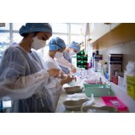 Une infirmière du service pneumologie de l'HIA Percy prépare des lots de médicaments en compagnie de deux étudiantes infirmières de l'EPPA pour le soin des patients atteints de la Covid-19.