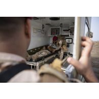 Un soldat irakien blessé est pris en charge par ses camarades à bord d'une ambulance sur le camp de Bagdad (Irak).