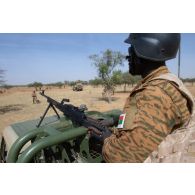 Un soldat burkinabè sécurise le périmètre au moyen d'une mitrailleuse PK à l'arrière de son pick-up dans la région de Tofagala, au Burkina Faso.