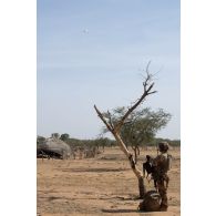 Un soldat du 16e bataillon de chasseurs à pied (16e BCP) sécurise le périmètre d'un village de la région de Tofagala, au Burkina Faso.