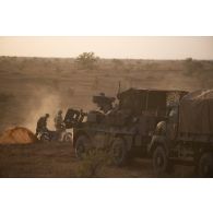 Des soldats burkinabè patrouillent à moto aux côtés des véhicules du 16e bataillon de chasseurs à pied (16e BCP) dans la région de Tofagala, au Burkina Faso.
