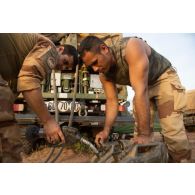 Des soldats du Service des essences des armées (SEA) aident au remplissage de jerricans depuis un camion-citerne dans la région de Tofagala, au Burkina Faso.