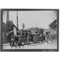 Des soldats britanniques de la BEF marchent en colonne dans une rue d'un village minier du département du Nord.