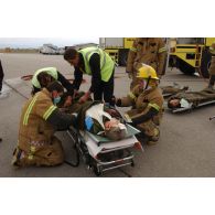 Triage des blessés selon les priorités d'urgence et premiers soins par les pompiers de l'aéroport et les médecins locaux avant évacuation.