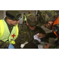 Tri des blessés dans la zone de triage avec ordre de priorité d'urgence, sous l'oeil des observateurs du service de santé.