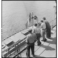 Des membres de l'équipage du cargo italien Tagliamento observent la vedette de la police de la navigation lors de l'arraisonnement du navire.