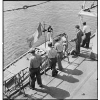 Des membres de l'équipage du cargo italien Tagliamento observent la vedette de la police de la navigation lors de l'arraisonnement du navire.