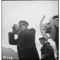 Un enseigne de vaisseau, de quart à la passerelle, observe l'horizon à bord de l'aviso Amiral Mouchez au large de Dunkerque.