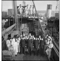 Portrait de groupe de l'état-major et de l'équipage du patrouilleur La Lorientaise, rassemblés sur le pont du navire à quai dans le port.