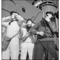 Marins sur le pont du Dunkerque après un tir de canon d'artillerie navale.