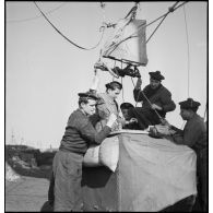 Des marins préparent la nacelle d'un ballon d'observation.