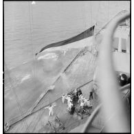 Vue en plongée depuis la superstructure sur les servants d'un canon double antiaérien de 37 mm à bord du cuirassé Dunkerque.