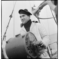 Marin manoeuvrant le transmetteur d'ordres, ou Chadburn, sur la passerelle du chasseur de sous-marins n°5. A droite, un tube acoustique.
