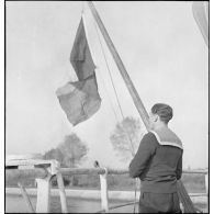 Le pavillon tricolore est hissé sur un navire marchand saisi par la Royal Navy et remis à la Marine nationale.