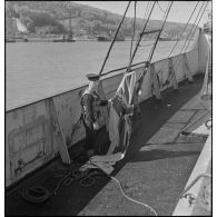 Un gabier britannique s'apprête à hisser l'Union Jack à bord d'un navire marchand saisi par la Royal Navy.