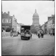Plusieurs personnes d'origine belge ont pris place dans un camion pour fuir leur pays envahi par l'armée allemande. A l'arrière-plan, le dôme de la basilique Notre-Dame de Boulogne-sur-Mer.