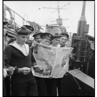 Des officiers mariniers, quartiers-maîtres et marins du contre-torpilleur Le Malin lisent la presse (quotidien Paris-Soir) et leur courrier.