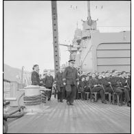 Le capitaine de vaisseau Henri Seguin, commandant du cuirassé Dunkerque, arrive sur le pont pour assister à une messe.