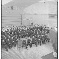 L'état-major, les officiers mariniers, l'équipage du cuirassé Dunkerque assistent à une messe sur le pont du navire.