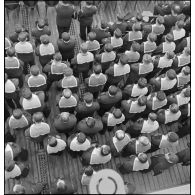 Officiers mariniers, quartiers-maîtres et marins assistent à une messe à bord du cuirassé Dunkerque.