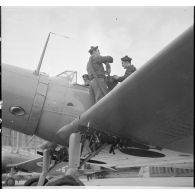 Deux matelots effectuent le plein de carburant d'un bombardier Vought 156 F de l'escadrille AB1 à Cherbourg.