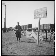 Une pancarte indiquant les feuillées dames est photographiée en plan général en bordure de voie ferrée.