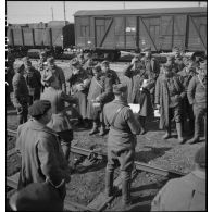 Photographie de groupe de soldats près d'une voie ferrée en gare de Trappes.